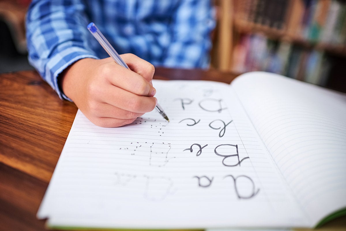 A child practices handwriting the alphabet.